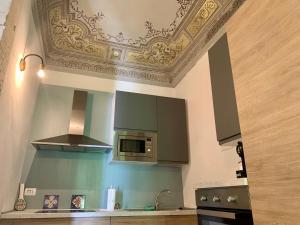 cocina con techo, fogones y microondas en Scicli for Family - Apartments, en Scicli
