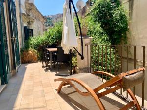 un patio con sombrilla, mesa y sillas en Scicli for Family - Apartments, en Scicli