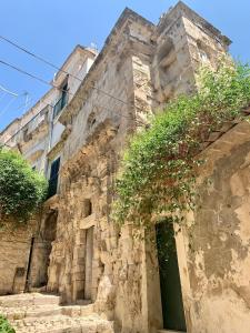un antiguo edificio de piedra con una puerta verde en Scicli for Family - Apartments, en Scicli