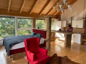 a bedroom with a bed and a red chair at Atelier mit Bergblick 