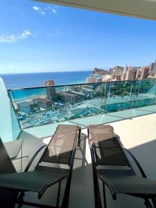 two chairs on a balcony with a view of the ocean at Sunset Drive Resort & Spa in Benidorm