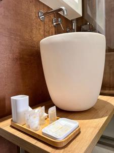 y baño con lavabo blanco y mesa de madera. en Dimora Elle en La Maddalena