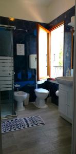 a bathroom with two toilets and a shower and a sink at RioB&B in Alfero