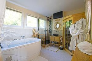 een badkamer met een groot bad en een douche bij Le Boudoir de Fanny - Sauna/Balnéo/ciné/Hamacs in Le Havre