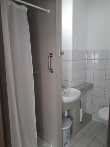 a bathroom with a sink and a shower curtain at Villa Vrest in Gdańsk