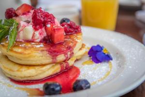 a stack of pancakes with fruit on a white plate at Ariel House in Dublin