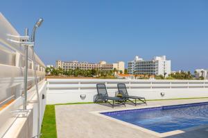 two chairs on the roof of a building with a swimming pool at Protaras Sol e Mar Villa 3 in Protaras