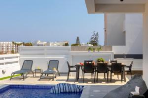 un patio con mesa y sillas junto a una piscina en Protaras Sol e Mar Villa 3, en Protaras
