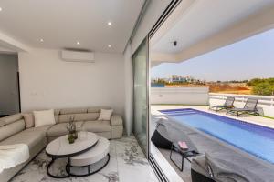 a living room with a couch and a swimming pool at Protaras Sol e Mar Villa 3 in Protaras +46 photos