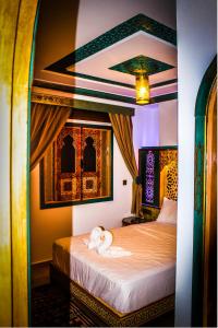 a bedroom with a bed with a stuffed animal on it at Riad Azemmat in Chefchaouene