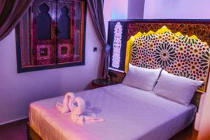 a bedroom with a bed with two towels on it at Riad Azemmat in Chefchaouen