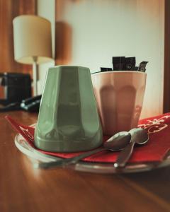 eine grüne Vase auf einem Teller auf einem Tisch in der Unterkunft Schlosspark-Hotel Hof von Oldenburg in Rastede