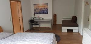 a bedroom with a desk and a bed and a table at die RAMPE in Bad Lauterberg