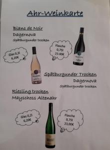 una lavagna bianca con bottiglie di vino in bolle di pensiero di Gästehaus - Café Frank ad Antweiler