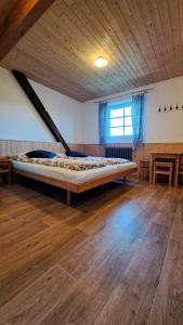 Cama grande en habitación con suelo de madera en Horský penzion VEBROVY BOUDY, en Pec pod Sněžkou