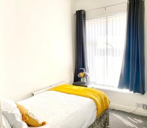 - une chambre avec un lit doté d'une couverture jaune et d'une fenêtre dans l'établissement Cosy Cheerful 2 Beds Near Piccadilly, Etihad Stadium Sleeps upto 5, à Manchester