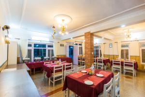 un restaurante con mesas y sillas en una habitación en Hotel Acme Inn en Katmandú