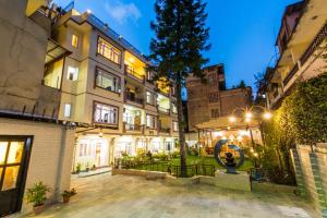 un edificio de apartamentos con patio por la noche en Hotel Acme Inn en Katmandú