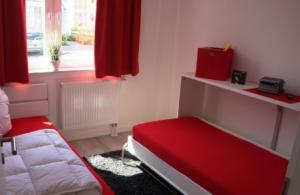 a bedroom with red curtains and a bed and a window at Ostseebrise 4 - Großenbrode in Großenbrode