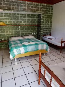 una camera con due letti in un muro di mattoni di Pousada Dos Arcos a Jacumã