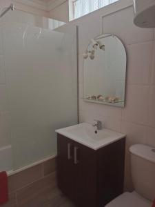 La salle de bains est pourvue d'un lavabo, d'un miroir et de toilettes. dans l'établissement Sunset view in La Romantica, 1, à Los Realejos