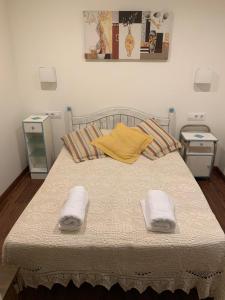 sypialnia z łóżkiem i dwoma ręcznikami na nim w obiekcie A de Maria - Tres Marias Apartments w mieście Redondela