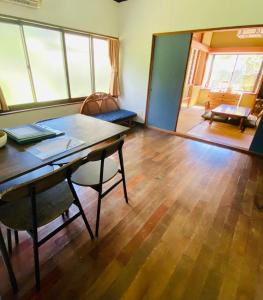 una sala da pranzo con tavolo e sedie e un soggiorno di Holiday Cottage BANSHIRO a Setouchi