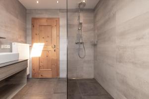 a bathroom with a shower and a glass door at Flo's Apartment in Grossarl +37 photos