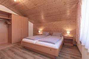 a bedroom with a bed and a wooden wall at Flo's Apartment in Grossarl