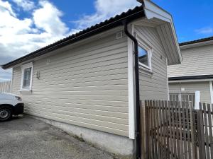 Ein weißes Haus mit einem Zaun daneben. in der Unterkunft Sentralt i Fredrikstad gratis parkering in Fredrikstad