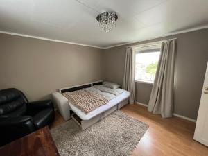 um quarto com uma cama, uma cadeira e uma janela em Sentralt i Fredrikstad gratis parkering em Fredrikstad