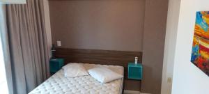 1 dormitorio pequeño con 1 cama con 2 mesitas de noche en Atalanta 201A, en Bombinhas