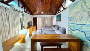 un salon avec une table et un canapé dans l'établissement Flat Siriguela, à Fernando de Noronha