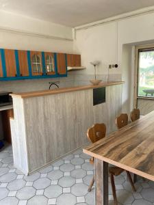 cocina con mesa de madera y sillas en Příjemný apartmán se zahradou, en Ostřešany