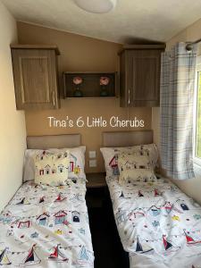 una camera con 2 letti singoli e lenzuola bianche di 6 Little Cherubs Holiday Home a Cowes