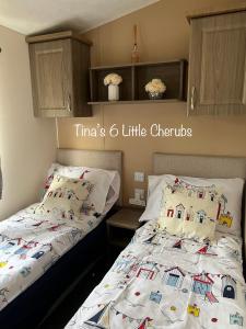 a bedroom with two twin beds with white comforters at 6 Little Cherubs Holiday Home in Cowes