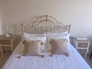 a large bed with white sheets and pillows at Villa Vanessa in Kissamos