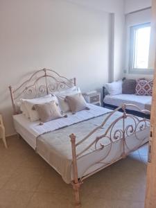 1 dormitorio con 1 cama grande con sábanas y almohadas blancas en Villa Vanessa, en Kissamos