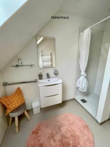 a bathroom with a sink and a mirror and a chair at Murmeltier in Hausen im Tal