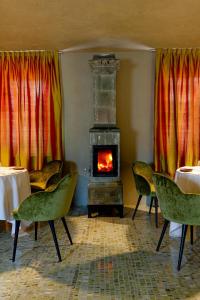 a room with a fireplace and chairs and a stove at Là Di Moret in Udine