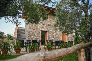 une maison en pierre avec des chaises devant elle dans l'établissement Il Casale del Barone, à San Giovanni a Piro