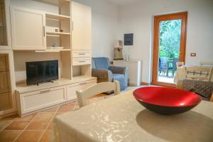 a living room with a tv and a red bowl on a table at Il Casale del Barone in San Giovanni a Piro