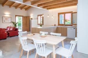 una cucina e un soggiorno con tavolo e sedie di Villa with pool near the beach in Cala San Vicente by Renthousing a Cala Sant Vicenç