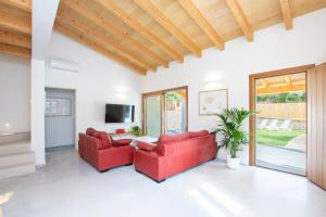 a living room with red couches and a table at Villa with pool near the beach in Cala San Vicente by Renthousing in Cala de Sant Vicent