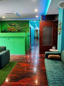 a lobby with a couch and a wall with a painting at Namaste Benares Varanasi in Varanasi
