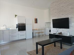 uma cozinha com electrodomésticos brancos e uma mesa num quarto em נוגה בגולן em Katzrin