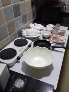 a counter top with white plates and bowls on it at ريلاكس ان للشقق الفندقية relax inn in Muscat