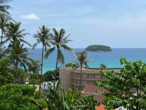 a view of a resort with palm trees and the ocean at KATA PENTHOUSE SEA VIEW private POOL in Kata Beach