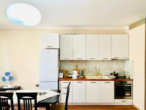 a kitchen with white cabinets and a table at Spacious Holiday Apartment in Tirana
