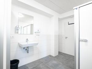 ein weißes Bad mit einem Waschbecken und einer Dusche in der Unterkunft Haus Jagstblick in Kirchberg an der Jagst